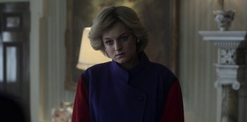 Movie still from “The Crown” (2016), created by Peter Morgan – A woman with blonde hair wearing a purple and red jacket; Medium shot, Low angle