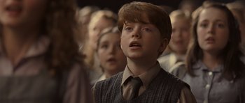 Movie still from “Never Let Me Go” (2010), directed by Mark Romanek – A young boy in a tie and a sweater; Close Up shot, Over the shoulder angle