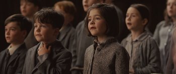 Movie still from “Never Let Me Go” (2010), directed by Mark Romanek – A young girl is standing in front of a group of other young people; Close Up shot, High angle