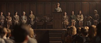 Movie still from “Never Let Me Go” (2010), directed by Mark Romanek – A group of people sitting at a podium in front of a crowd; Wide shot, High angle