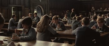 Movie still from “Never Let Me Go” (2010), directed by Mark Romanek – A group of people sitting at a table eating food; Medium shot, Over the shoulder angle