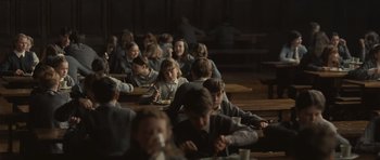Movie still from “Never Let Me Go” (2010), directed by Mark Romanek – A group of children sitting at a table eating food; Wide shot, High angle