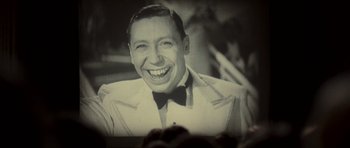 Movie still from “Never Let Me Go” (2010), directed by Mark Romanek – An old black and white photo of a man smiling; Close Up shot, Low angle