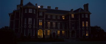Movie still from “Never Let Me Go” (2010), directed by Mark Romanek – A building that is lit up at night time; Extreme Wide shot, High angle