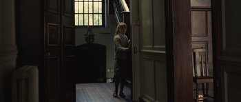 Movie still from “Never Let Me Go” (2010), directed by Mark Romanek – A woman standing at the entrance of a room; Wide shot, High angle
