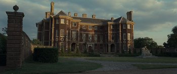 Movie still from “Never Let Me Go” (2010), directed by Mark Romanek – A large brick building with many windows on a cloudy day; Extreme Wide shot, Low angle