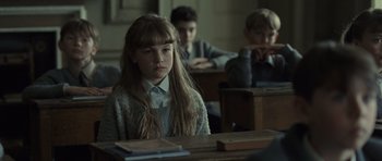 Movie still from “Never Let Me Go” (2010), directed by Mark Romanek – A girl sitting at a desk in a classroom; Medium shot, Over the shoulder angle