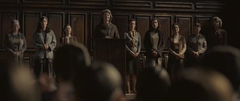 Movie still from “Never Let Me Go” (2010), directed by Mark Romanek – A group of women standing in front of a podium; Medium shot, Low angle