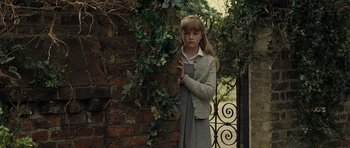 Movie still from “Never Let Me Go” (2010), directed by Mark Romanek – A young girl standing in front of a brick wall; Medium shot, Over the shoulder angle