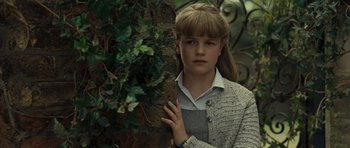 Movie still from “Never Let Me Go” (2010), directed by Mark Romanek – A girl leaning against a wall with a plant in the background; Close Up shot, Low angle