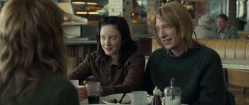 Movie still from “Never Let Me Go” (2010), directed by Mark Romanek – Two people are sitting at a table with drinks; Medium shot, Over the shoulder angle