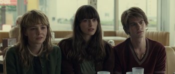 Movie still from “Never Let Me Go” (2010), directed by Mark Romanek – A woman sitting next to two other people; Close Up shot, Over the shoulder angle