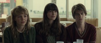 Movie still from “Never Let Me Go” (2010), directed by Mark Romanek – A woman sitting next to two other people; Close Up shot, Over the shoulder angle
