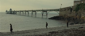 Movie still from “Never Let Me Go” (2010), directed by Mark Romanek – A person walking on the beach near the water; Extreme Wide shot, Low angle
