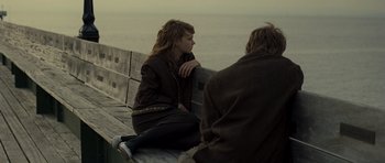 Movie still from “Never Let Me Go” (2010), directed by Mark Romanek – A woman sitting on a bench next to a man; Medium shot, Over the shoulder angle