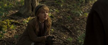 Movie still from “Never Let Me Go” (2010), directed by Mark Romanek – A young girl sitting on the ground in the woods; Medium shot, Over the shoulder angle