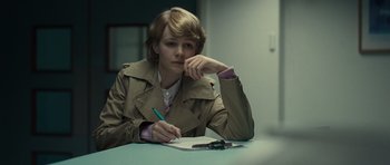 Movie still from “Never Let Me Go” (2010), directed by Mark Romanek – A woman sitting at a table writing on a piece of paper; Medium shot, Over the shoulder angle