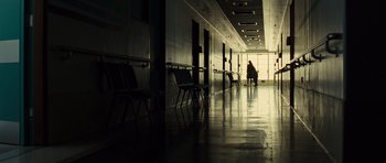 Movie still from “Never Let Me Go” (2010), directed by Mark Romanek – A person is sitting alone in an empty room; Extreme Wide shot, Low angle