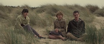 Movie still from “Never Let Me Go” (2010), directed by Mark Romanek – Two people sitting in the sand on the beach; Medium shot, Low angle