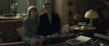 Movie still from “Never Let Me Go” (2010), directed by Mark Romanek – A man and a woman sitting on a couch in a living room; Medium shot, Over the shoulder angle