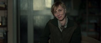 Movie still from “Never Let Me Go” (2010), directed by Mark Romanek – A woman with short blonde hair wearing a green jacket; Close Up shot, Over the shoulder angle