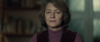 Movie still from “Never Let Me Go” (2010), directed by Mark Romanek – An older woman wearing a purple sweater and a purple vest; Close Up shot, Over the shoulder angle