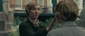 Movie still from “Never Let Me Go” (2010), directed by Mark Romanek – A woman in a green jacket is holding her hand up to her face; Close Up shot, Over the shoulder angle