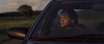 Movie still from “Never Let Me Go” (2010), directed by Mark Romanek – A woman sitting in the driver's seat of a car; Close Up shot, Over the shoulder angle