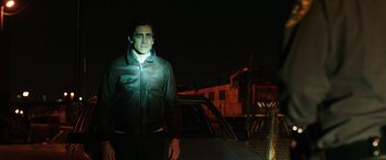 Movie still from “Nightcrawler” (2014), directed by Dan Gilroy – A man standing in front of a car at night; Medium shot, Low angle