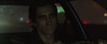 Movie still from “Nightcrawler” (2014), directed by Dan Gilroy – A person sitting in a car at night; Close Up shot, Over the shoulder angle