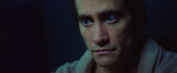 Movie still from “Nightcrawler” (2014), directed by Dan Gilroy – A man's face in a dimly - lit room; Close Up shot, Low angle