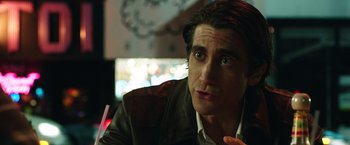 Movie still from “Nightcrawler” (2014), directed by Dan Gilroy – A person sitting in front of a clock; Close Up shot, Over the shoulder angle