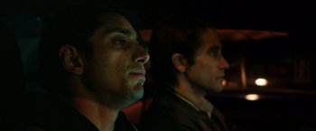 Movie still from “Nightcrawler” (2014), directed by Dan Gilroy – Two men sitting side by side in a dark room; Close Up shot, Over the shoulder angle