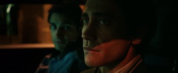 Movie still from “Nightcrawler” (2014), directed by Dan Gilroy – Two men are sitting next to each other in the dark; Close Up shot, Over the shoulder angle