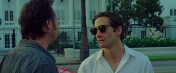 Movie still from “Nightcrawler” (2014), directed by Dan Gilroy – A man wearing sunglasses talking to another man; Close Up shot, Over the shoulder angle