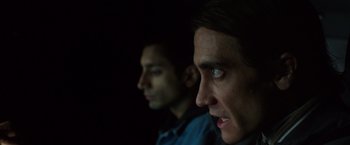Movie still from “Nightcrawler” (2014), directed by Dan Gilroy – Two men are looking into the distance in the dark; Close Up shot, Over the shoulder angle