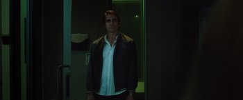 Movie still from “Nightcrawler” (2014), directed by Dan Gilroy – A man standing in front of a mirror in a dark room; Medium shot, Low angle