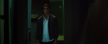 Movie still from “Nightcrawler” (2014), directed by Dan Gilroy – A man standing in front of a window in a dark room; Medium shot, Low angle
