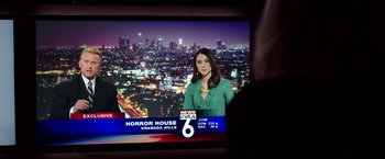 Movie still from “Nightcrawler” (2014), directed by Dan Gilroy – A woman in front of a television with a city skyline in the background; Close Up shot, Over the shoulder angle