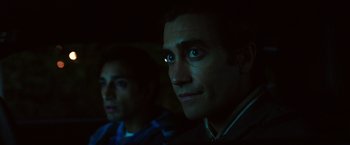 Movie still from “Nightcrawler” (2014), directed by Dan Gilroy – Two men are sitting next to each other in the dark; Close Up shot, Over the shoulder angle