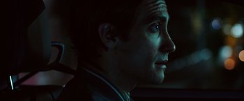 Movie still from “Nightcrawler” (2014), directed by Dan Gilroy – A person with a car in the background; Close Up shot, Over the shoulder angle