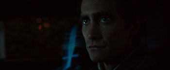 Movie still from “Nightcrawler” (2014), directed by Dan Gilroy – A person's face in the dark; Close Up shot, Over the shoulder angle