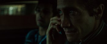 Movie still from “Nightcrawler” (2014), directed by Dan Gilroy – A person talking on a cell phone; Close Up shot, Over the shoulder angle