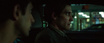 Movie still from “Nightcrawler” (2014), directed by Dan Gilroy – A man sitting in the back seat of a car at night; Close Up shot, Over the shoulder angle