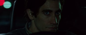 Movie still from “Nightcrawler” (2014), directed by Dan Gilroy – A person's face in the dark; Close Up shot, Over the shoulder angle