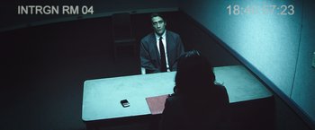 Movie still from “Nightcrawler” (2014), directed by Dan Gilroy – A man sitting at a table in front of a woman; Medium shot, Over the shoulder angle