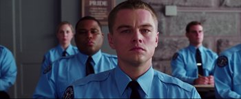 Movie still from “The Departed” (2006), directed by Martin Scorsese – A man in a police uniform is looking at the camera; Close Up shot, Low angle