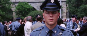 Movie still from “The Departed” (2006), directed by Martin Scorsese – A man in a police uniform standing in front of a group of people; Close Up shot, Low angle