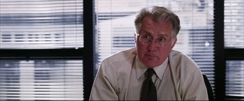 Movie still from “The Departed” (2006), directed by Martin Scorsese – An older man wearing glasses and wearing a tie; Close Up shot, Over the shoulder angle