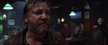 Movie still from “The Departed” (2006), directed by Martin Scorsese – A person with a beard in a room; Close Up shot, Over the shoulder angle